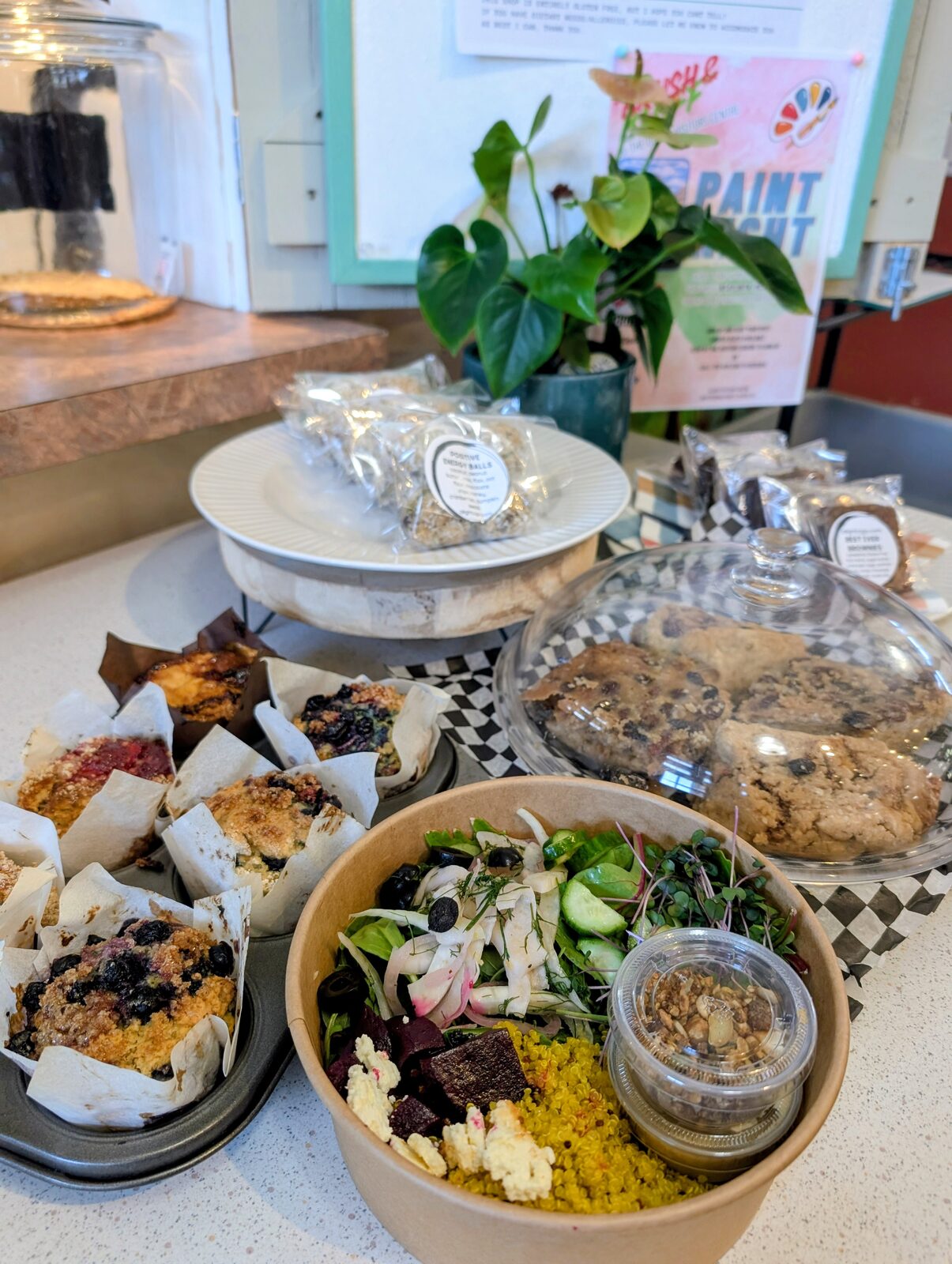 Bakery counter with muffins, energy balls, scones and a fresh bowl