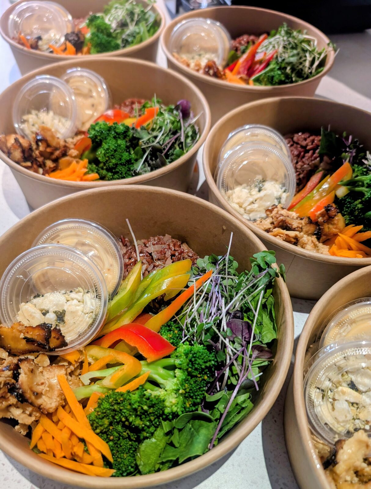 Six rice bowls with grilled chicken, broccoli, peppers and feta — group lunch catering